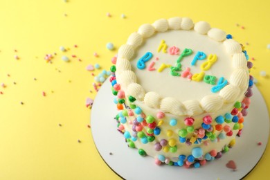 Photo of Cute bento cake with tasty cream on yellow background, space for text