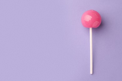 Tasty lollipop on violet background, top view. Space for text