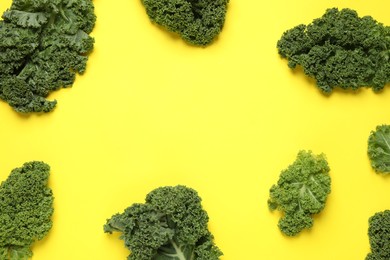 Photo of Fresh kale leaves on yellow background, flat lay. Space for text