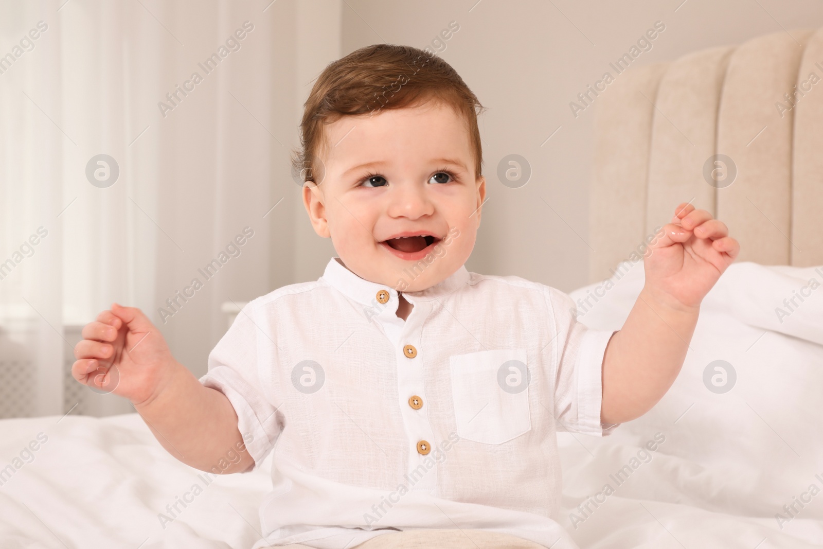 Photo of Happy baby boy on bed at home