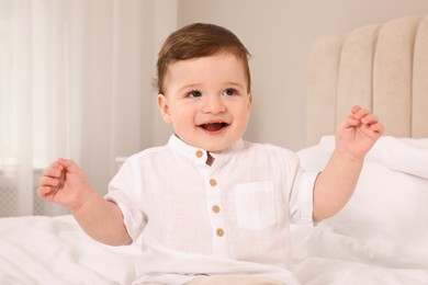 Happy baby boy on bed at home