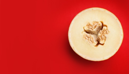 Half of ripe tasty melon on red background, top view. Space for text