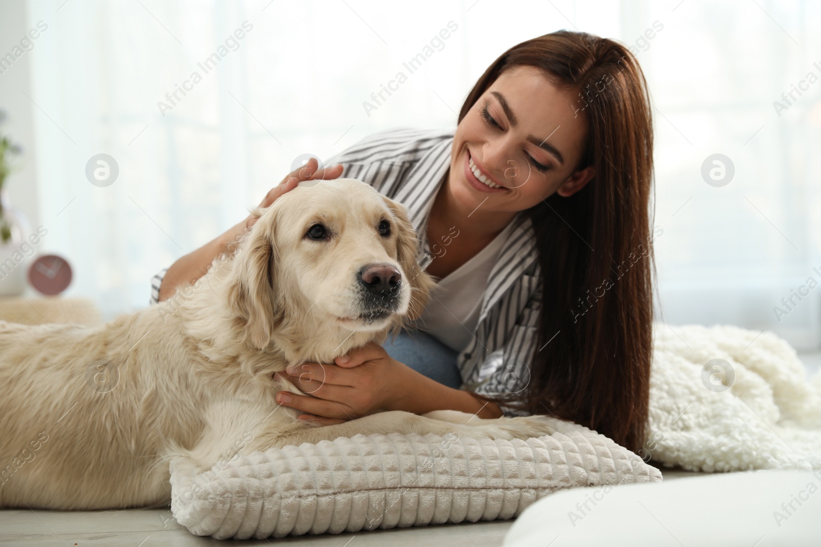 Photo of Young woman and her Golden Retriever at home. Adorable pet