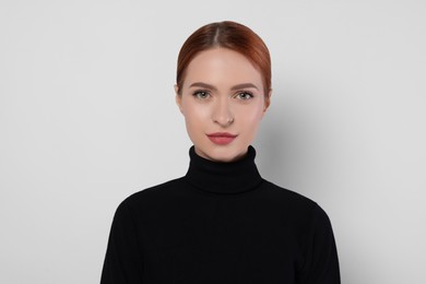 Portrait of beautiful young woman on light gray background