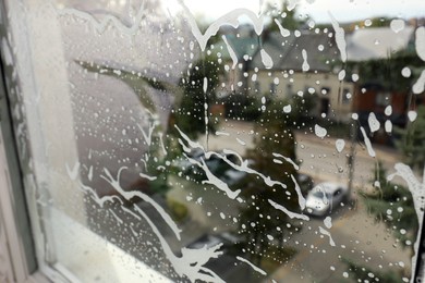 Photo of Cleaning foam on window glass, closeup view