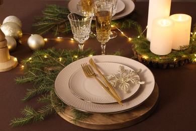 Christmas table setting with burning candles and festive decor