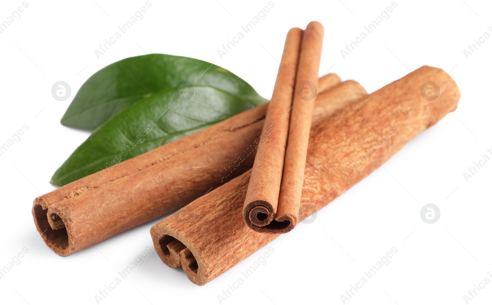 Photo of Cinnamon sticks and green leaves isolated on white