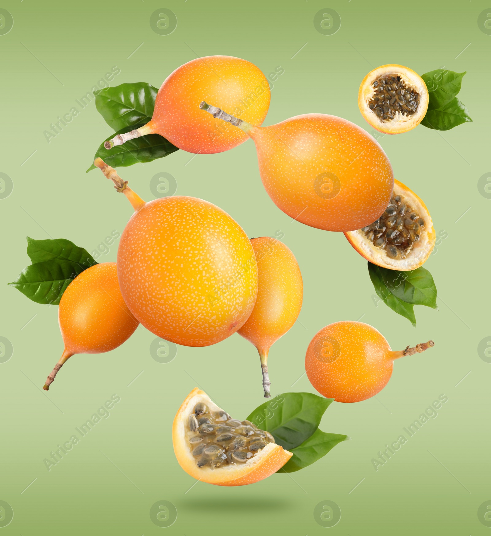 Image of Delicious ripe granadillas with leaves falling on light green background