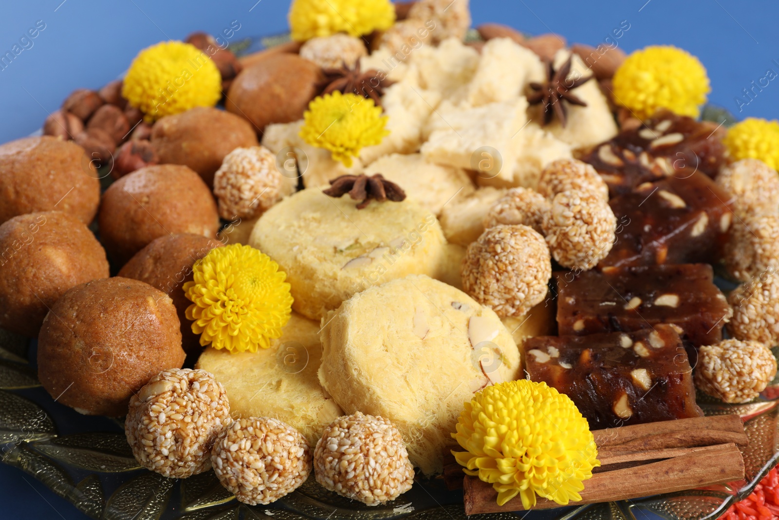 Photo of Diwali celebration. Tasty Indian sweets, spices and nuts on table, closeup