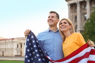 Photo of Couple with American flag on city street