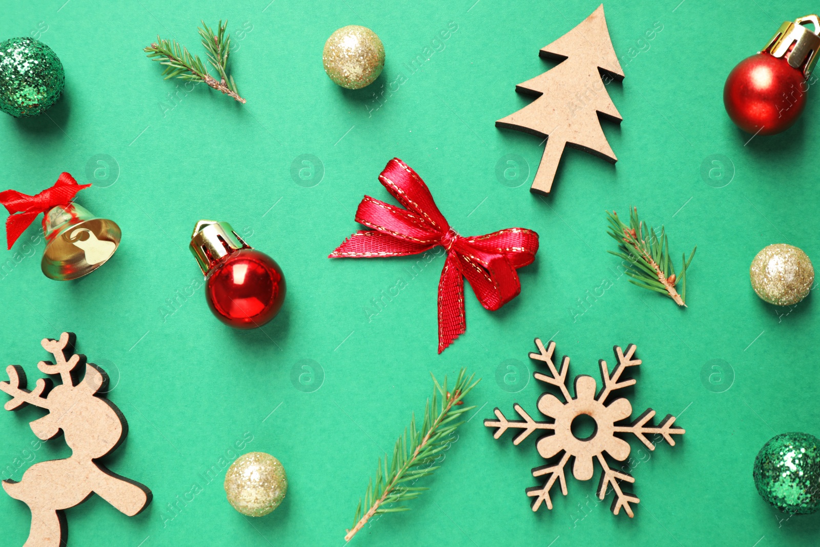 Photo of Flat lay composition with Christmas tree branches and festive decor on green background