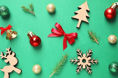 Flat lay composition with Christmas tree branches and festive decor on green background