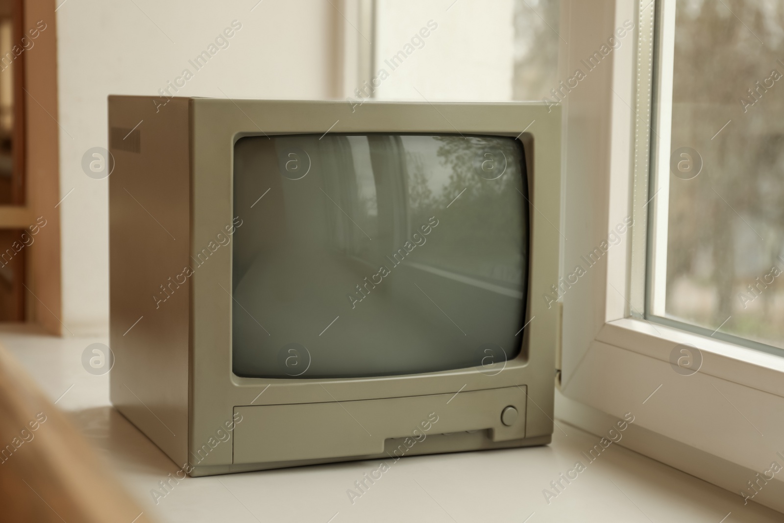 Photo of Old tv set on white windowsill indoors