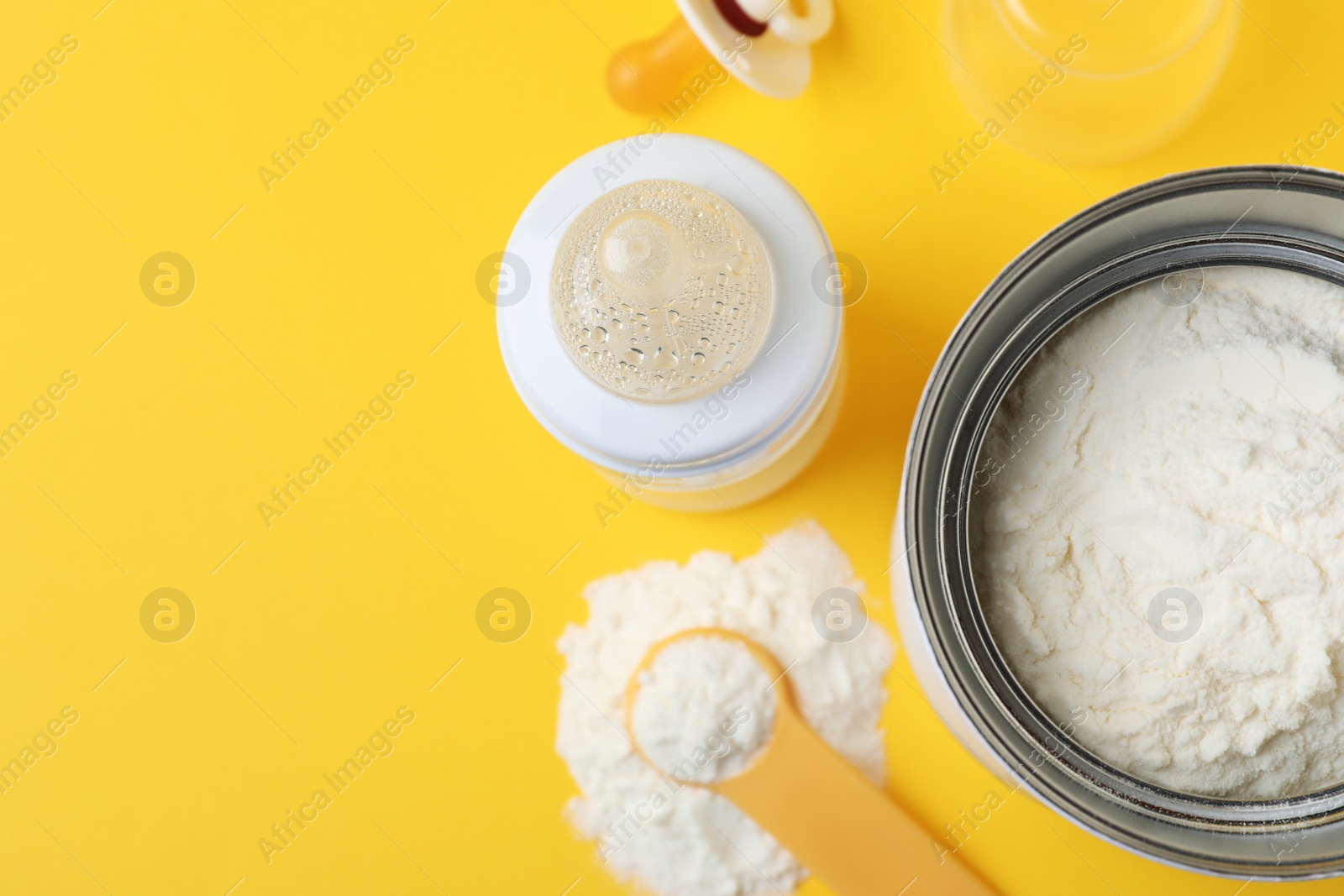 Photo of Flat lay composition with powdered infant formula on yellow background, space for text. Baby milk