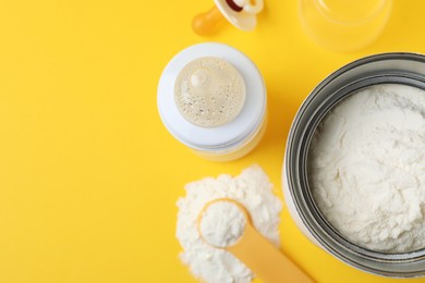 Photo of Flat lay composition with powdered infant formula on yellow background, space for text. Baby milk