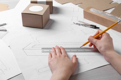 Woman creating packaging design at table, closeup