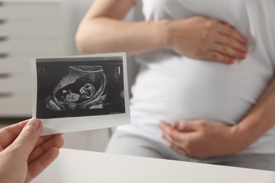 Pregnant woman having appointment in hospital, focus on doctor with ultrasound scan