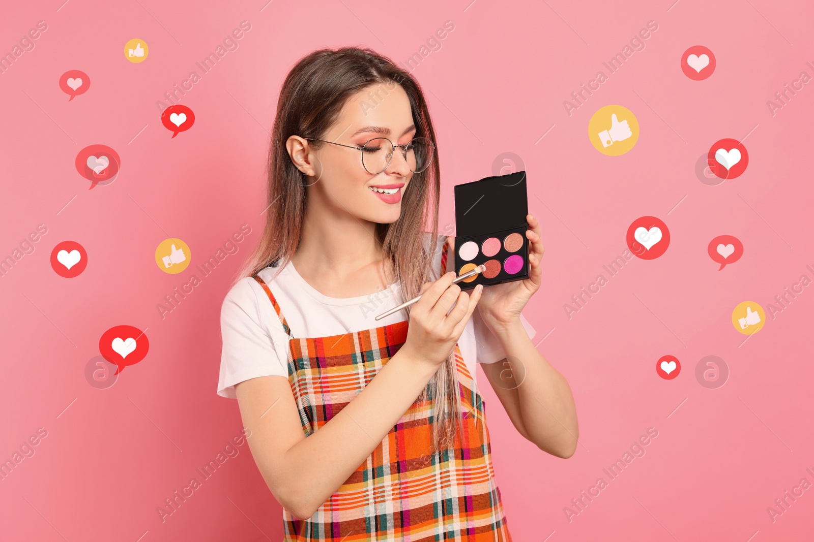 Image of Beauty blogger with brush and eyeshadow palette on pink background