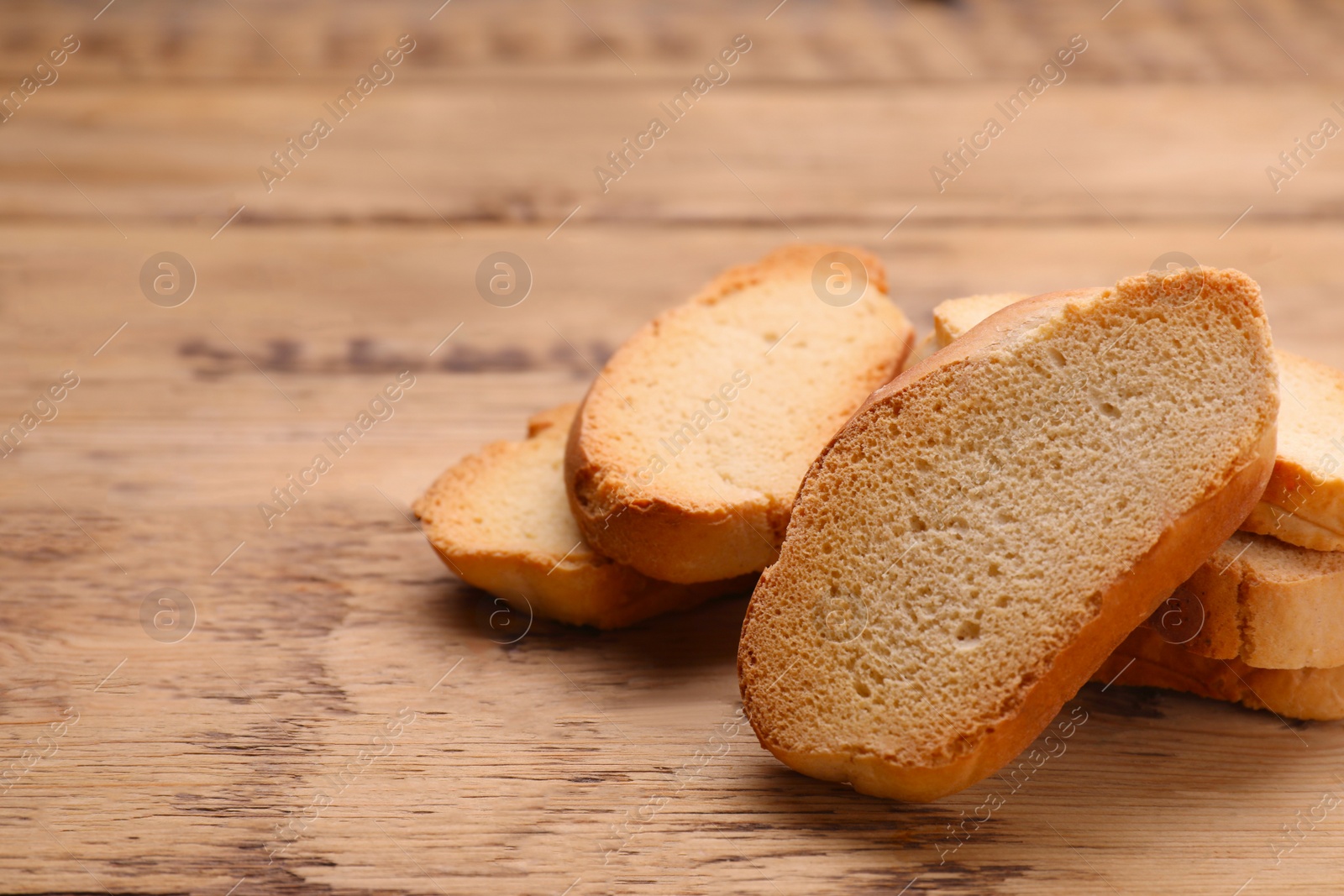 Photo of Tasty hard chuck crackers on wooden table, closeup. Space for text