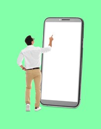 Image of Businessman using big smartphone on aquamarine background