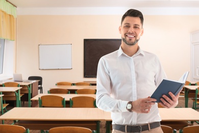 Image of Teacher with book waiting for students in classroom
