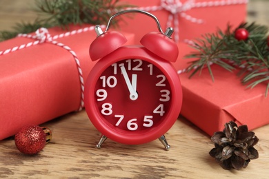 Beautiful composition with alarm clock and Christmas gifts on wooden table. Boxing day