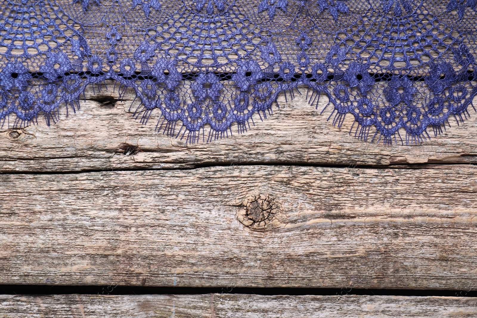 Photo of Beautiful lace on wooden table, top view. Space for text