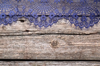 Photo of Beautiful lace on wooden table, top view. Space for text