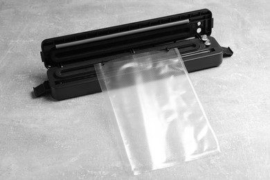 Photo of Sealer for vacuum packing with plastic bag on light grey table