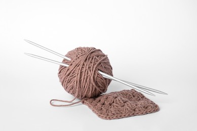 Photo of Soft brown woolen yarn, knitting and metal needles on white background