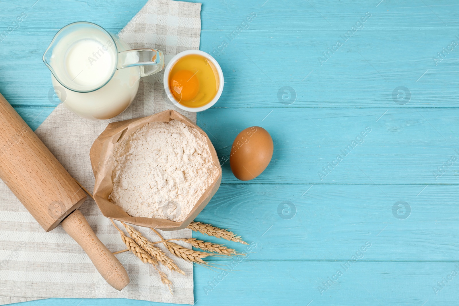 Photo of Flat lay composition with eggs and other ingredients on light blue wooden table, space for text. Baking pie