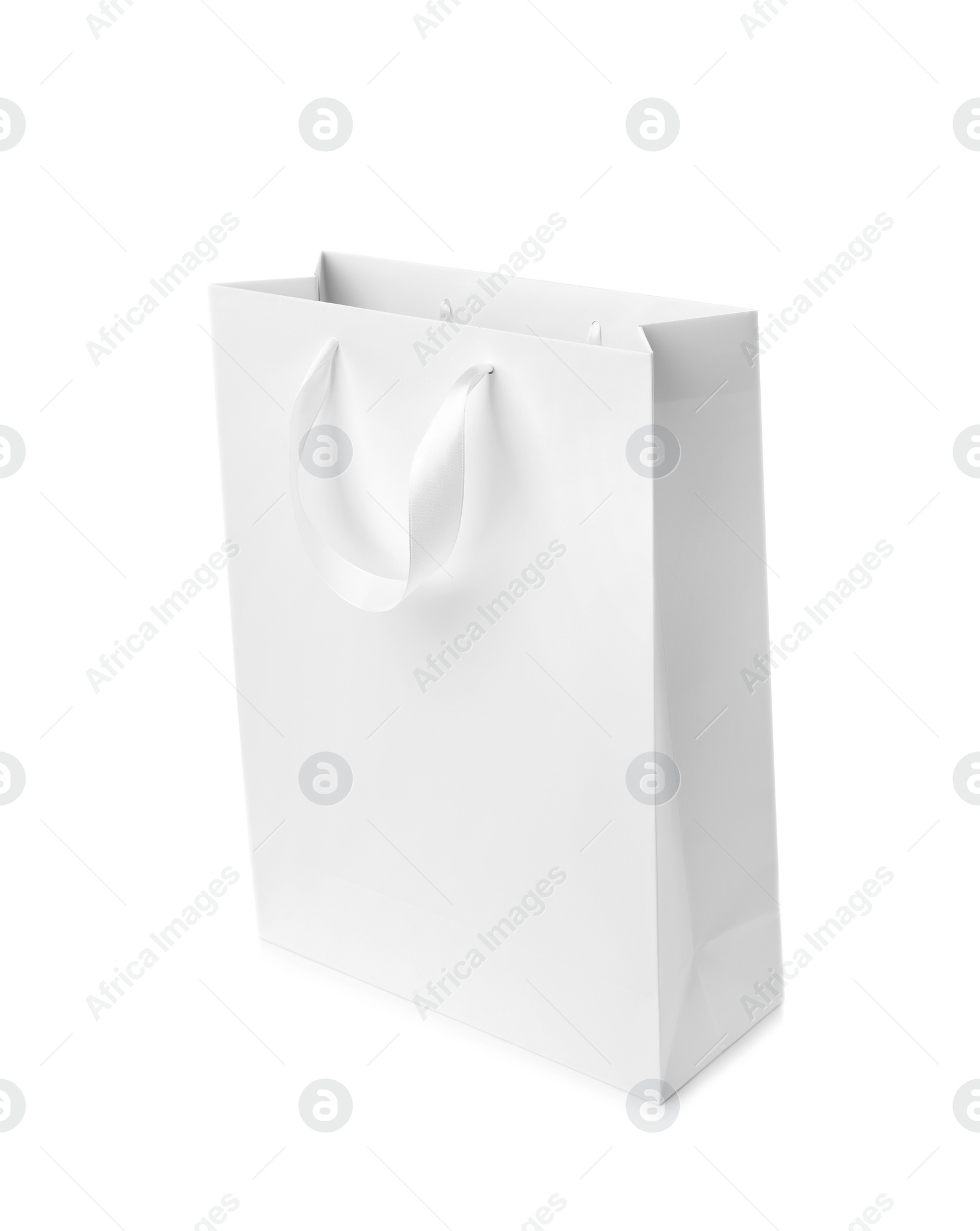 Photo of Paper shopping bag with ribbon handles on white background. Mockup for design