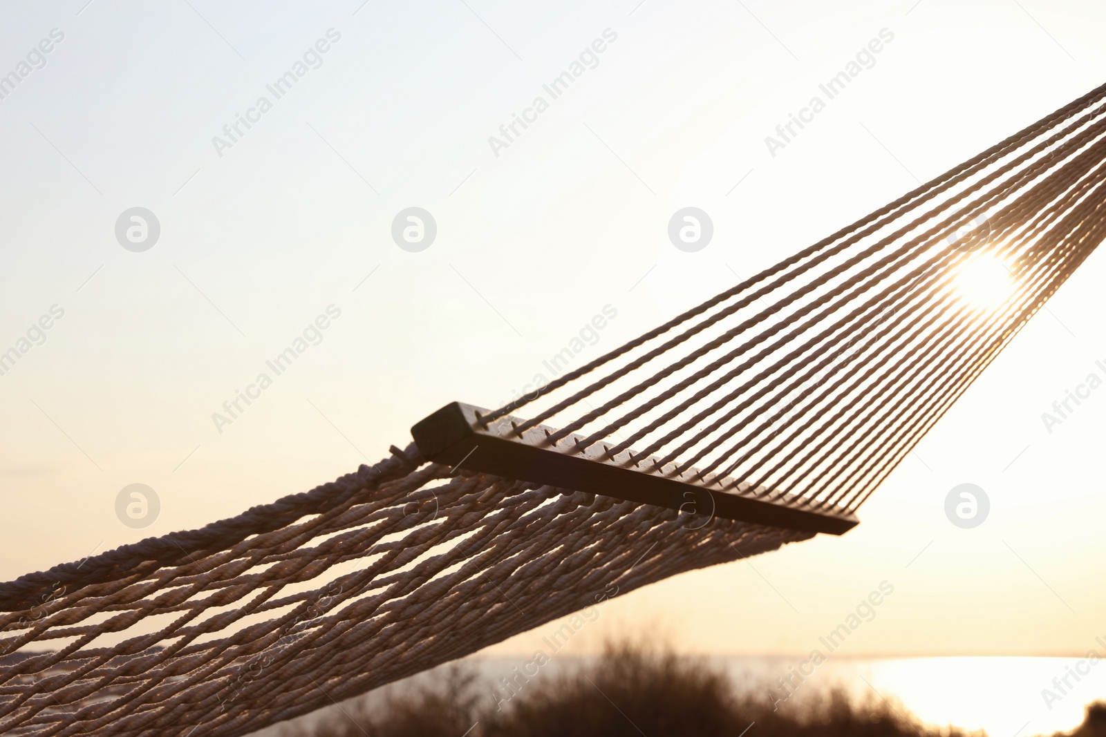 Photo of Empty hammock hanging outdoors. Time to relax