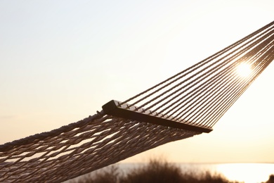 Photo of Empty hammock hanging outdoors. Time to relax