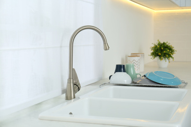 Clean dishes drying on rack in modern kitchen