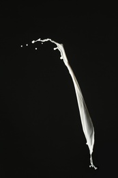 Photo of Splash of fresh milk on black background