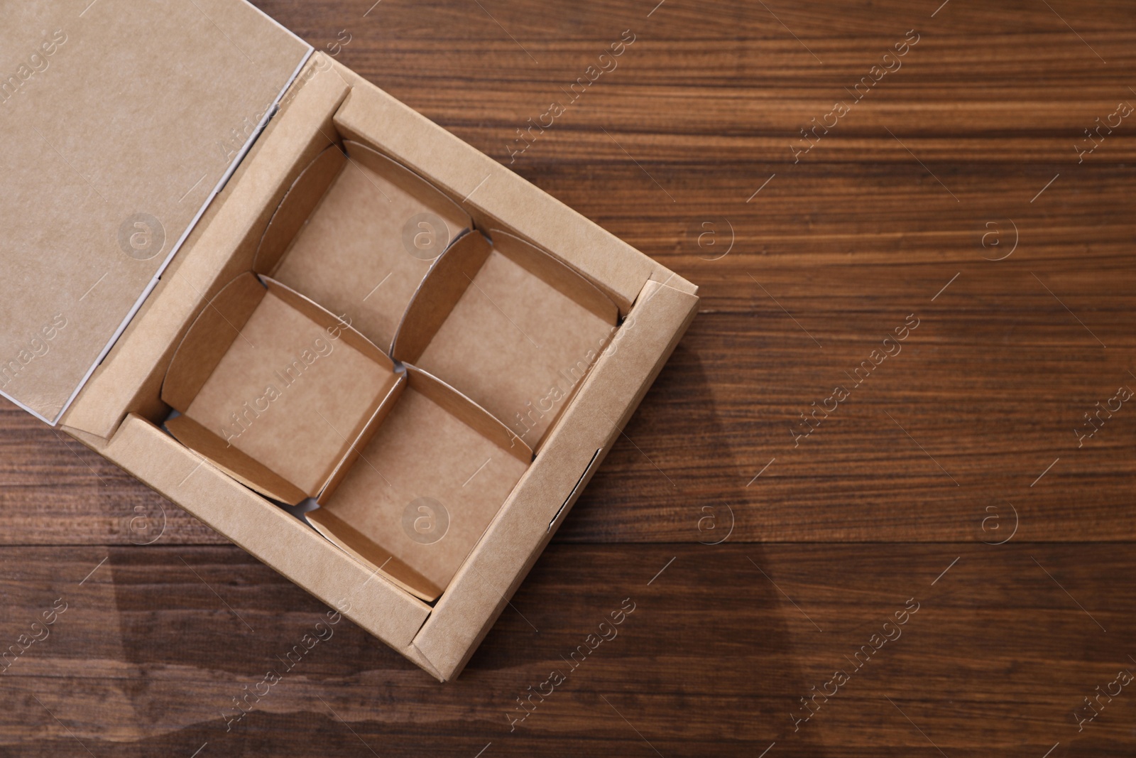 Photo of Empty packaging box with dividers on wooden table, top view. Space for text