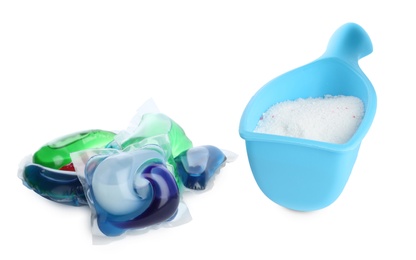 Photo of Laundry capsules and measuring scoop of washing powder on white background