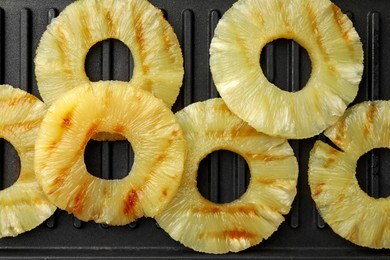 Tasty grilled pineapple slices on grill tray, flat lay