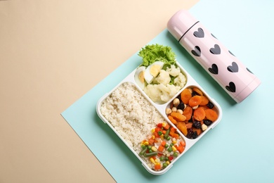 Thermos and lunch box with food on color background, flat lay. Space for text