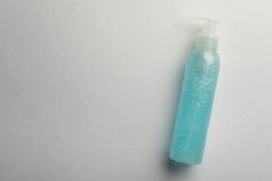 Photo of Bottle of blue cosmetic gel on light background, top view. Space for text