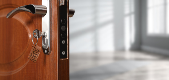 Image of Closeup view of door with key open into empty room