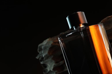 Photo of Luxury men`s perfume in bottle against dark background, space for text