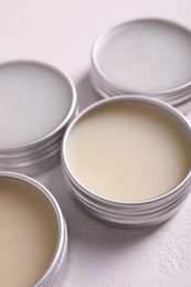 Photo of Different lip balms on white table, closeup