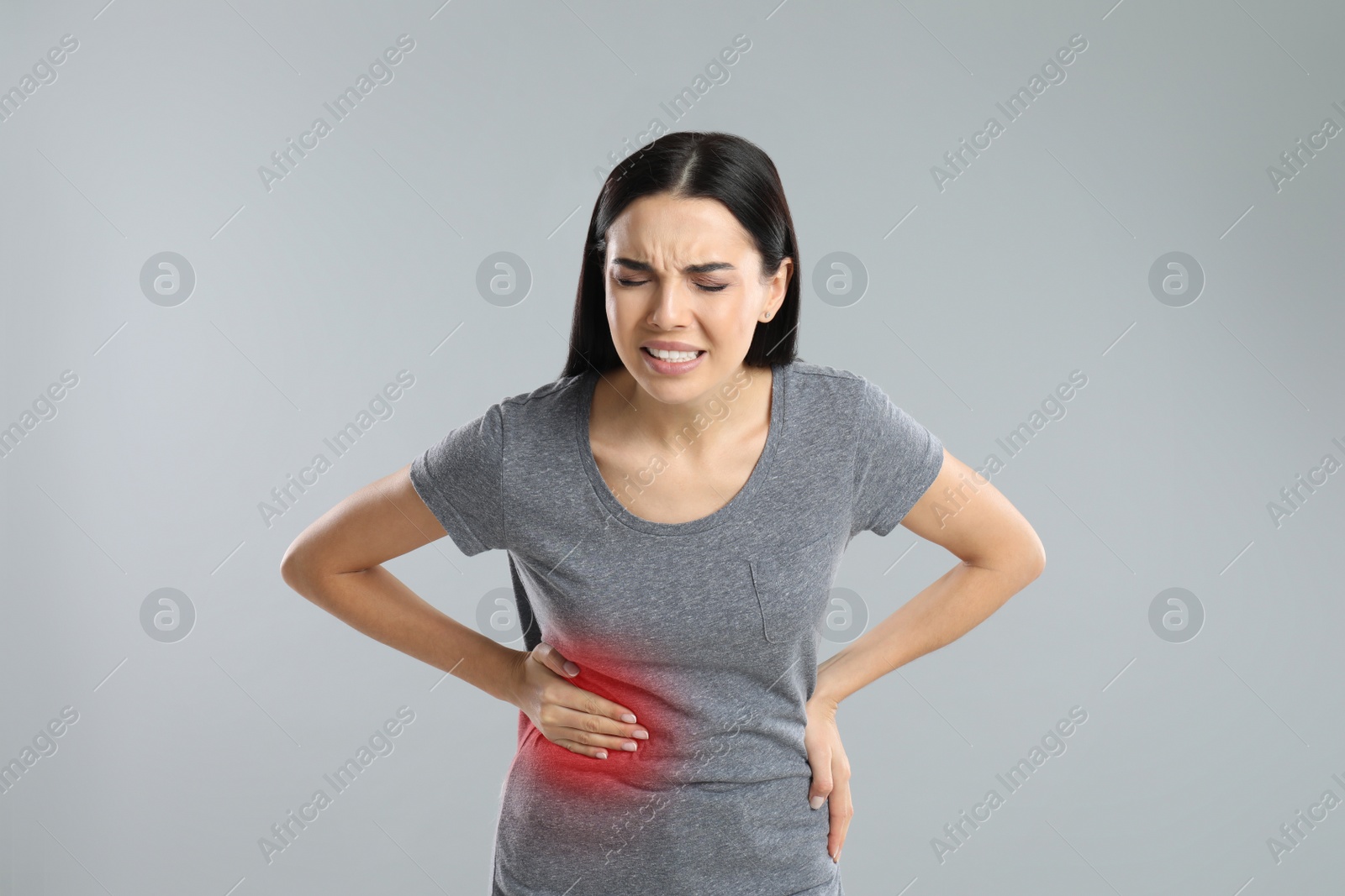 Photo of Woman suffering from liver pain on grey background