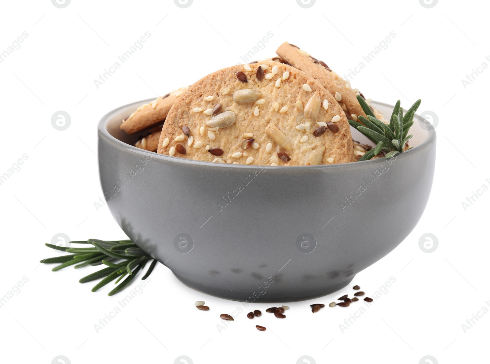 Photo of Round cereal crackers with flax, sunflower, sesame seeds and rosemary in bowl isolated on white