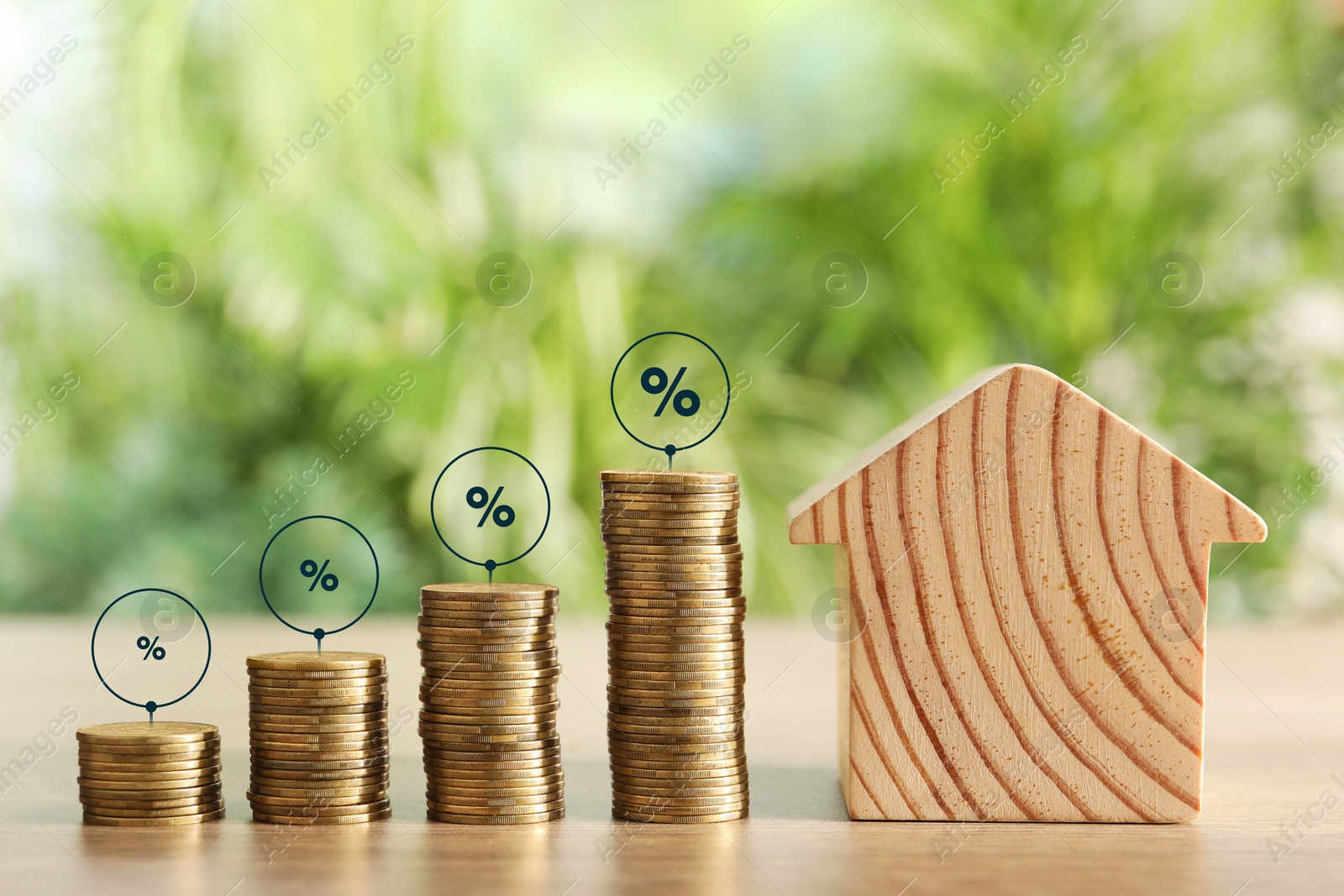 Image of Mortgage rate. Stacked coins, percent signs and wooden model of house