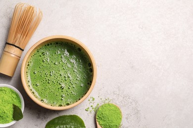 Bowl of fresh matcha tea, bamboo whisk and powder on light table, flat lay. Space for text