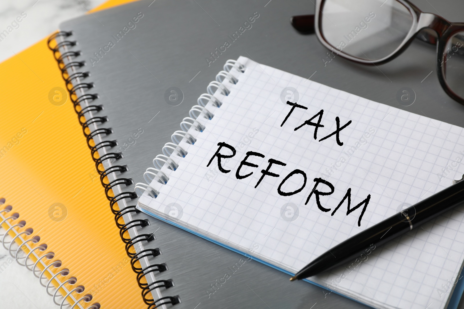 Image of Notebook with words TAX REFORM on table