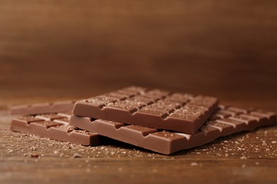 Tasty sweet chocolate bars on wooden table